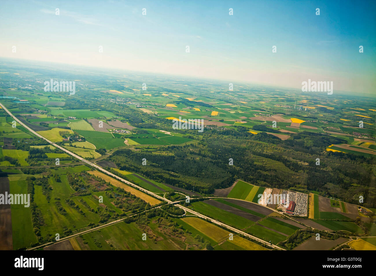 Hermosa vista aérea de la campiña bávara alrededor del aeropuerto de Múnich en primavera con campos de colza amarillos Foto de stock