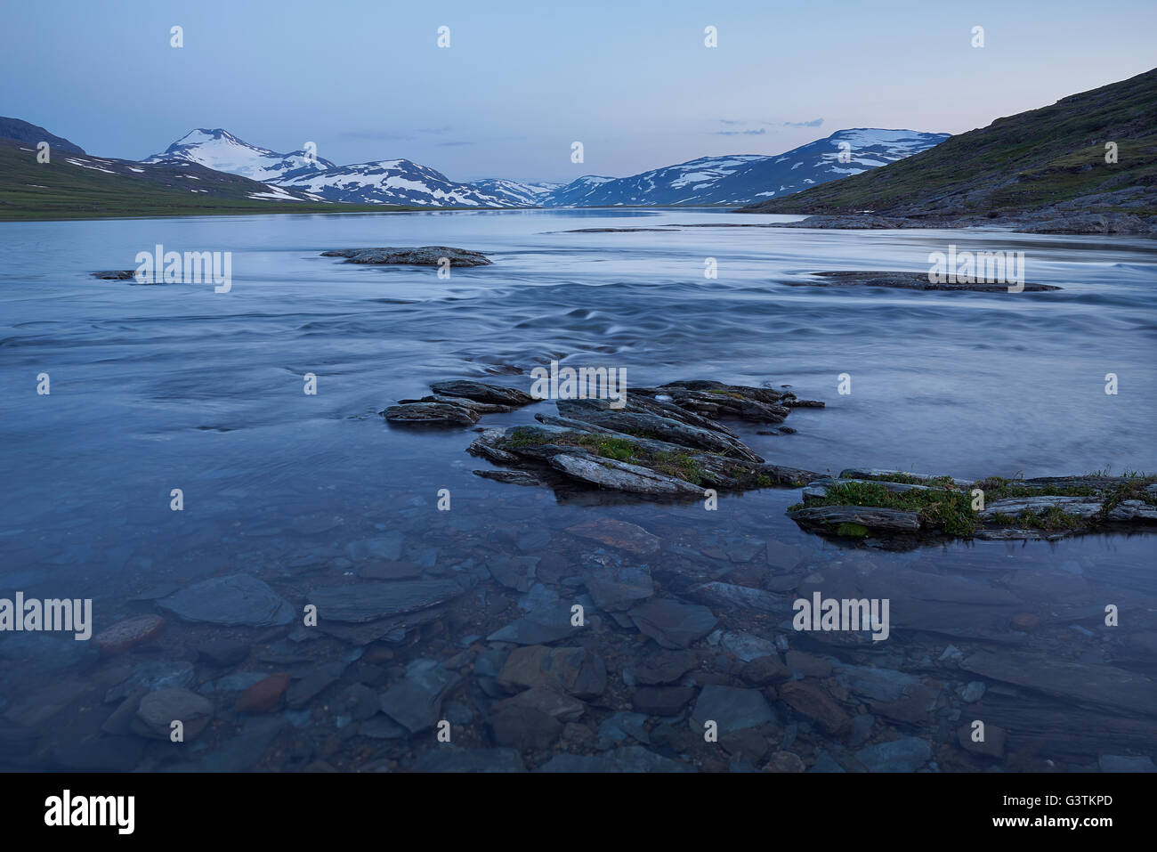 Suecia, Laponia, el Parque Nacional Padjelanta Sarjasjaure, lago al atardecer, la montaña en segundo plano. Foto de stock