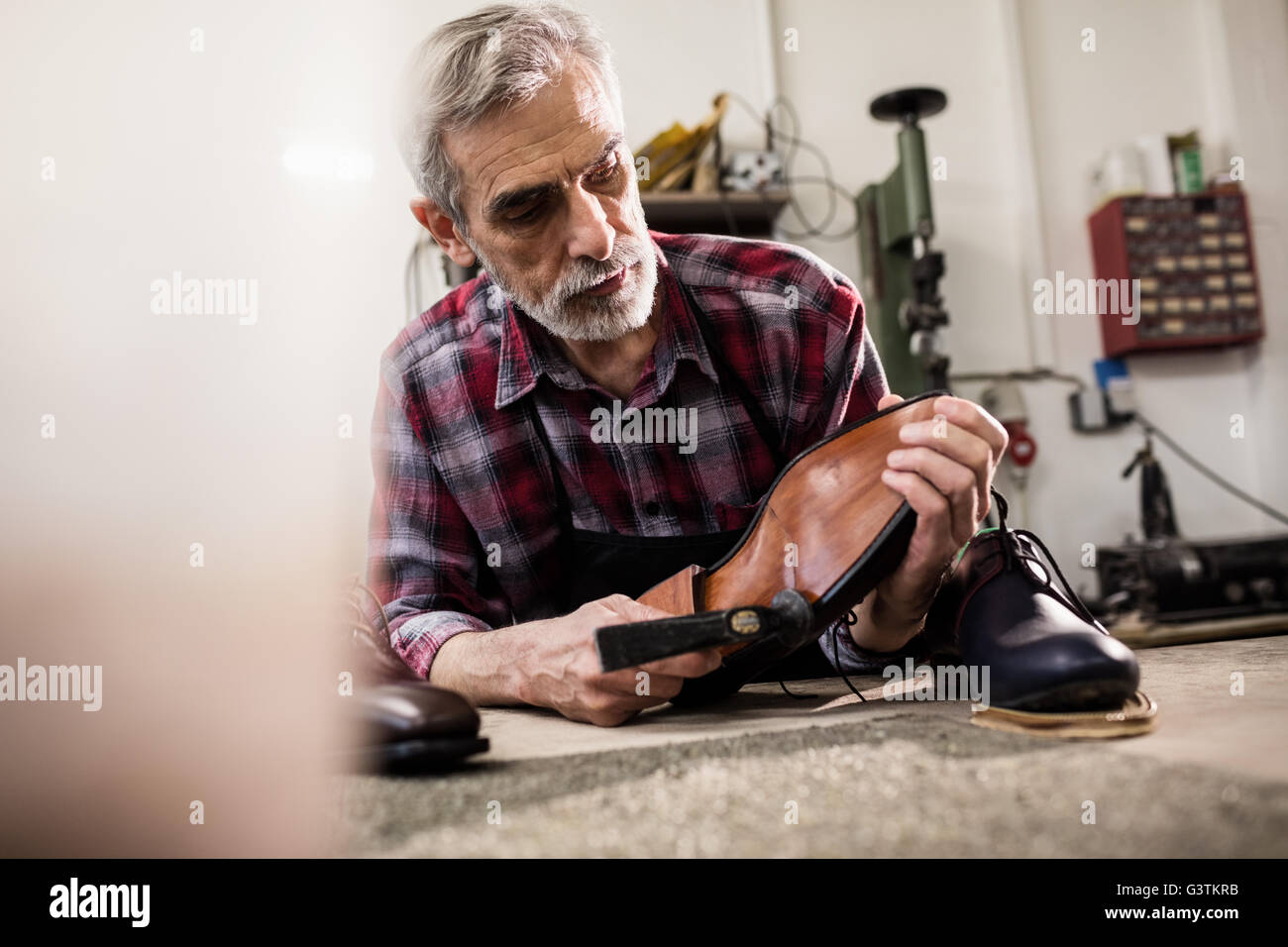 Zapatero insistiendo en la suela de un zapato Foto de stock