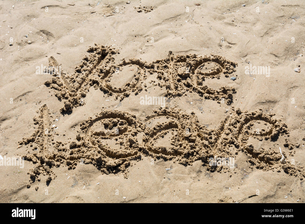 "Vote dejar" escrito en la arena. Foto de stock