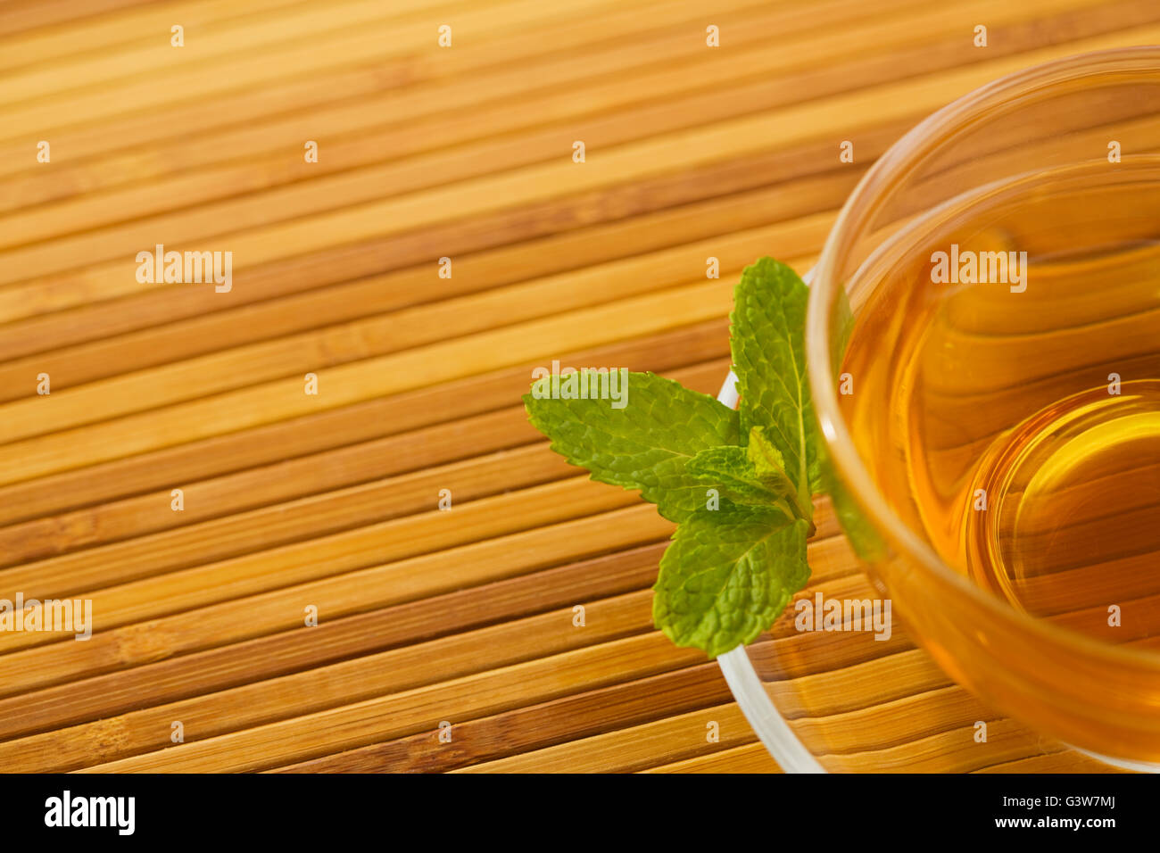 En la taza de té con hojas de menta sobre platillo Foto de stock