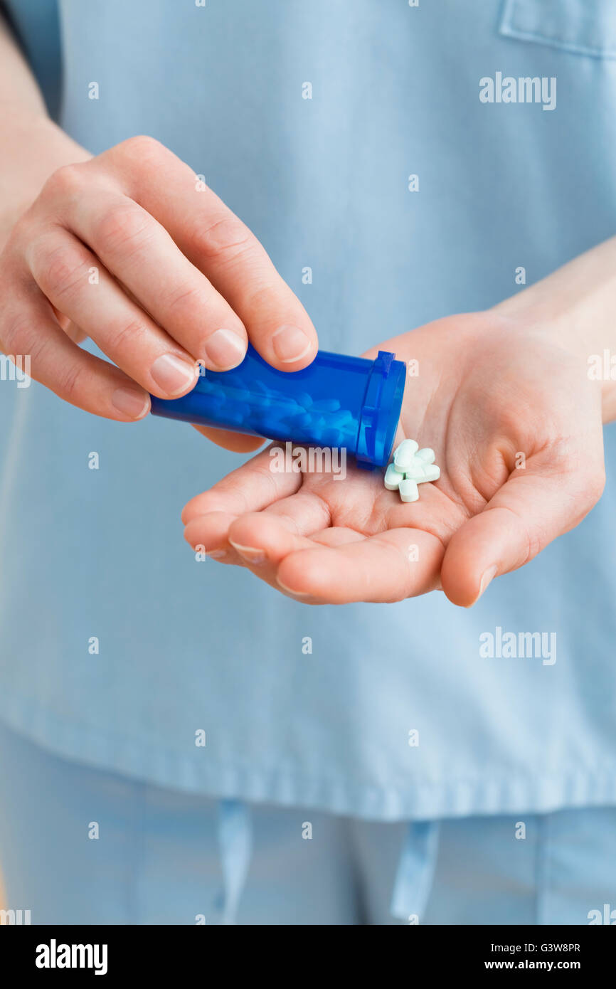 Enfermera con pastillas en la mano Foto de stock