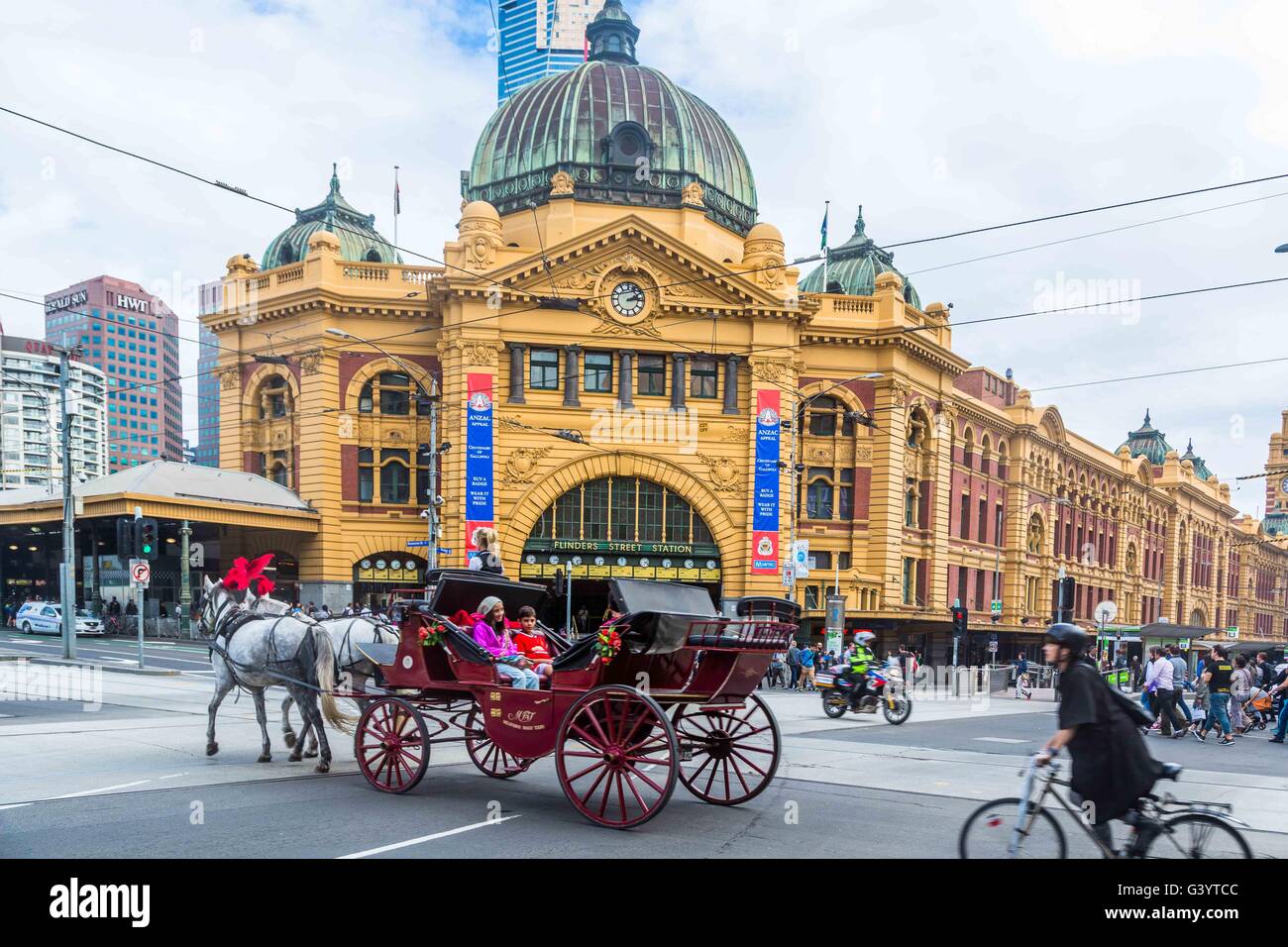 Un carruaje tirado por caballos cruza en frente de la estación de Flinders Street, de la ciudad de Melbourne, Australia Foto de stock