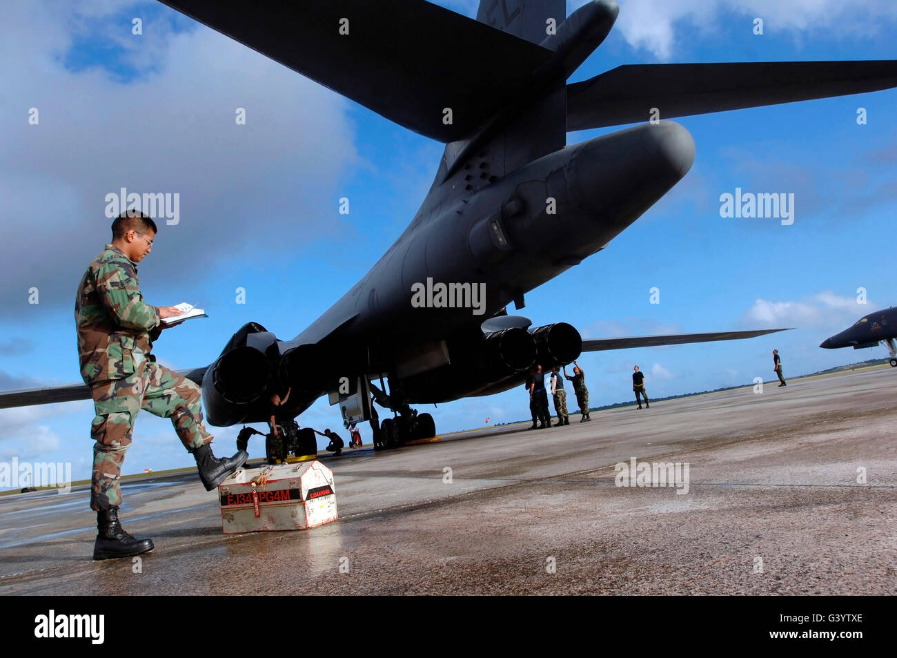 El B-1B Lancer mecánica inspeccione sus aviones antes de una incursión de la mañana. Foto de stock