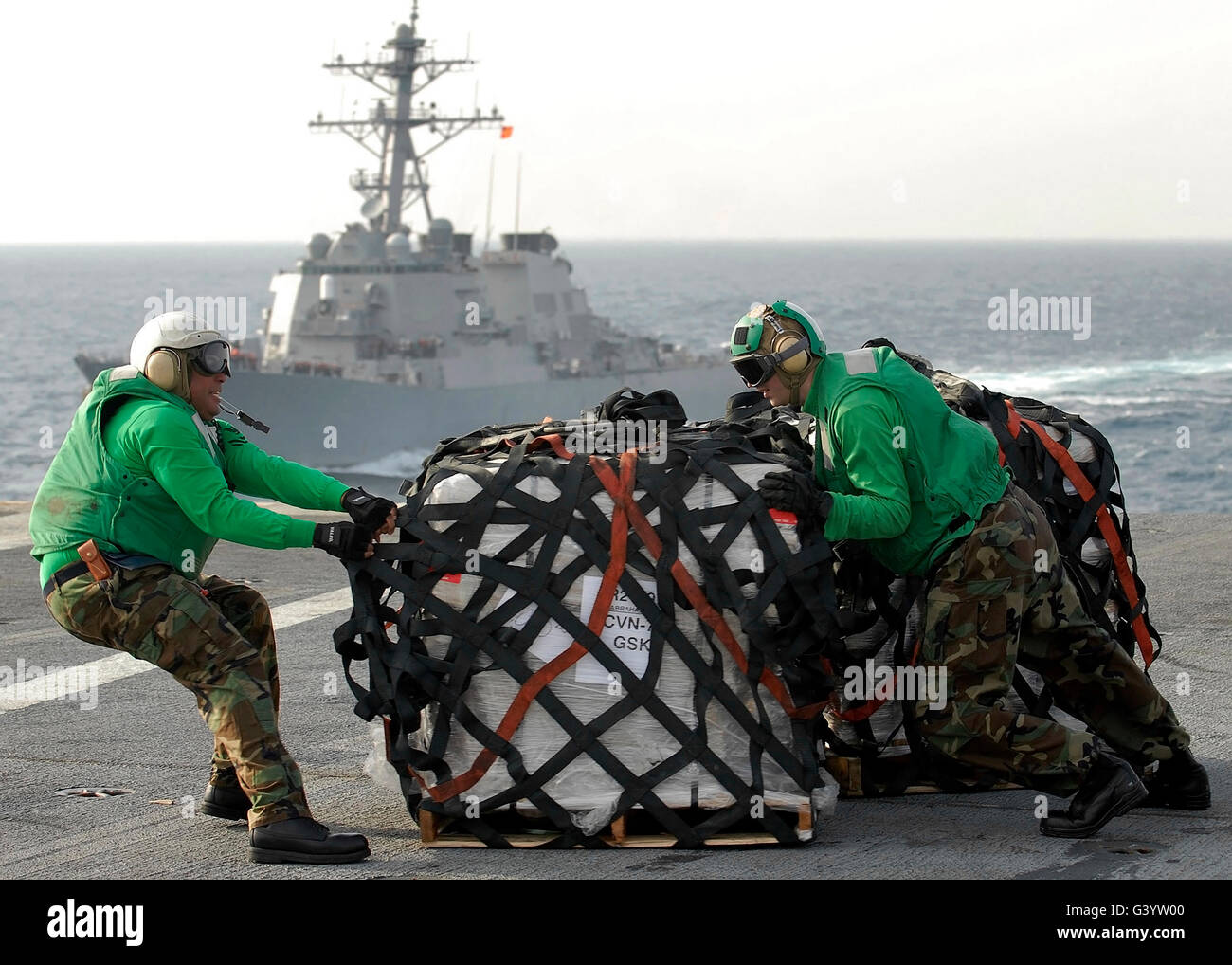 Los marineros pasar los suministros en la cubierta de vuelo a bordo del USS Abraham Lincoln. Foto de stock