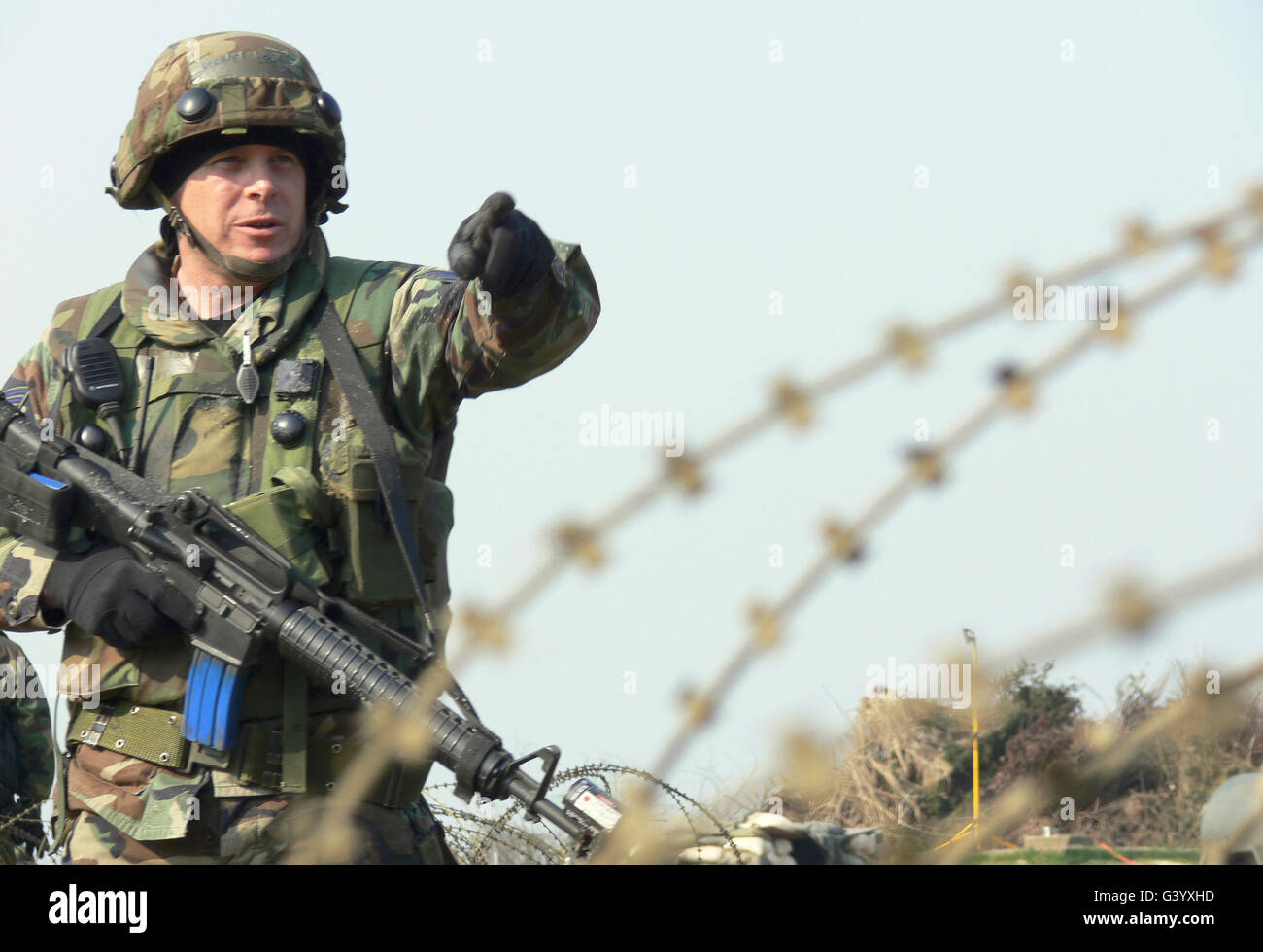 El soldado llama a acercarse a los lugareños. Foto de stock