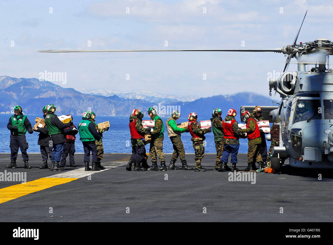 Los marineros y Marines suministros de carga en un HH-60H Seahawk. Foto de stock