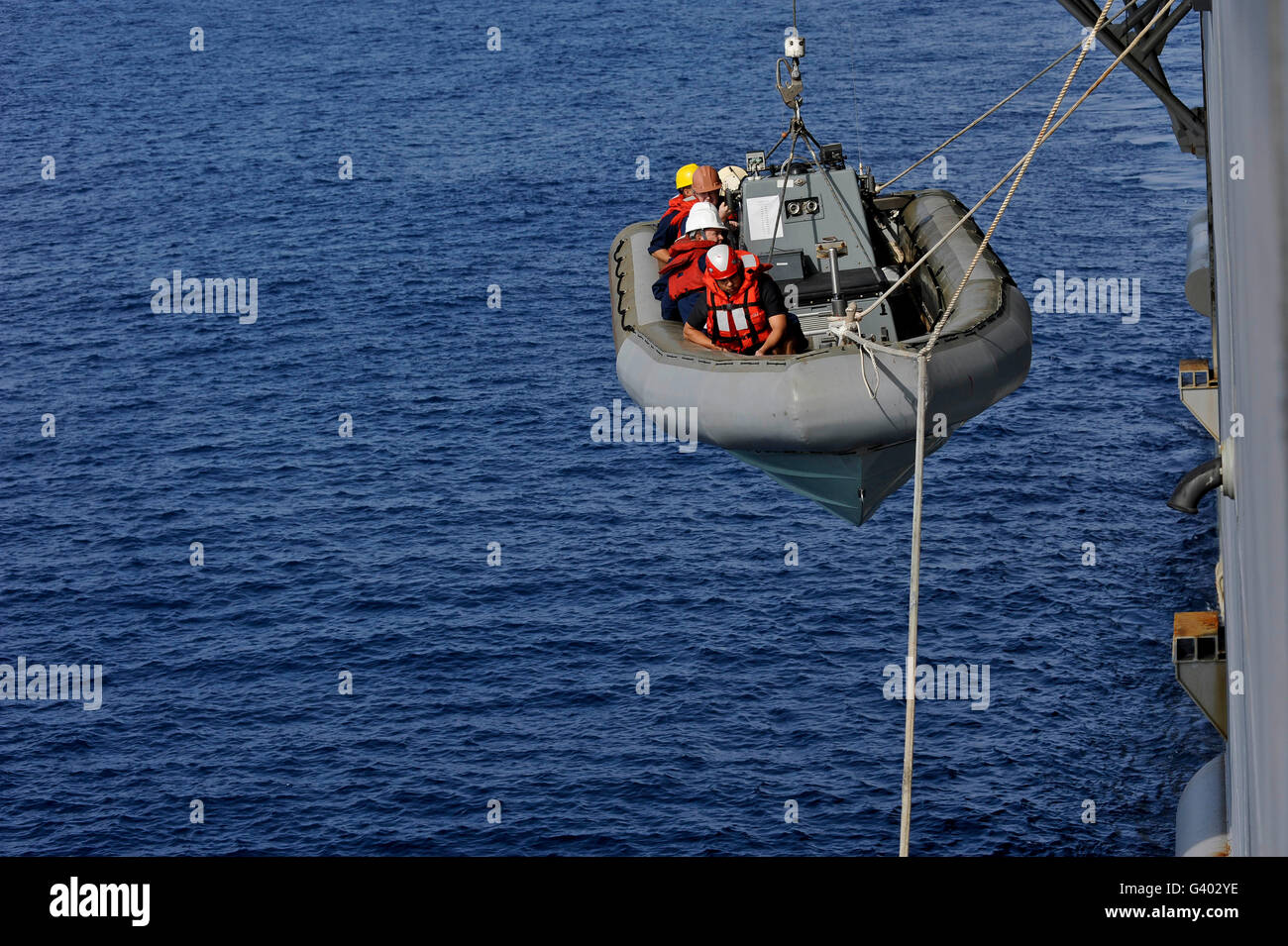 Los marineros bajar una embarcación inflable de casco rígido. Foto de stock