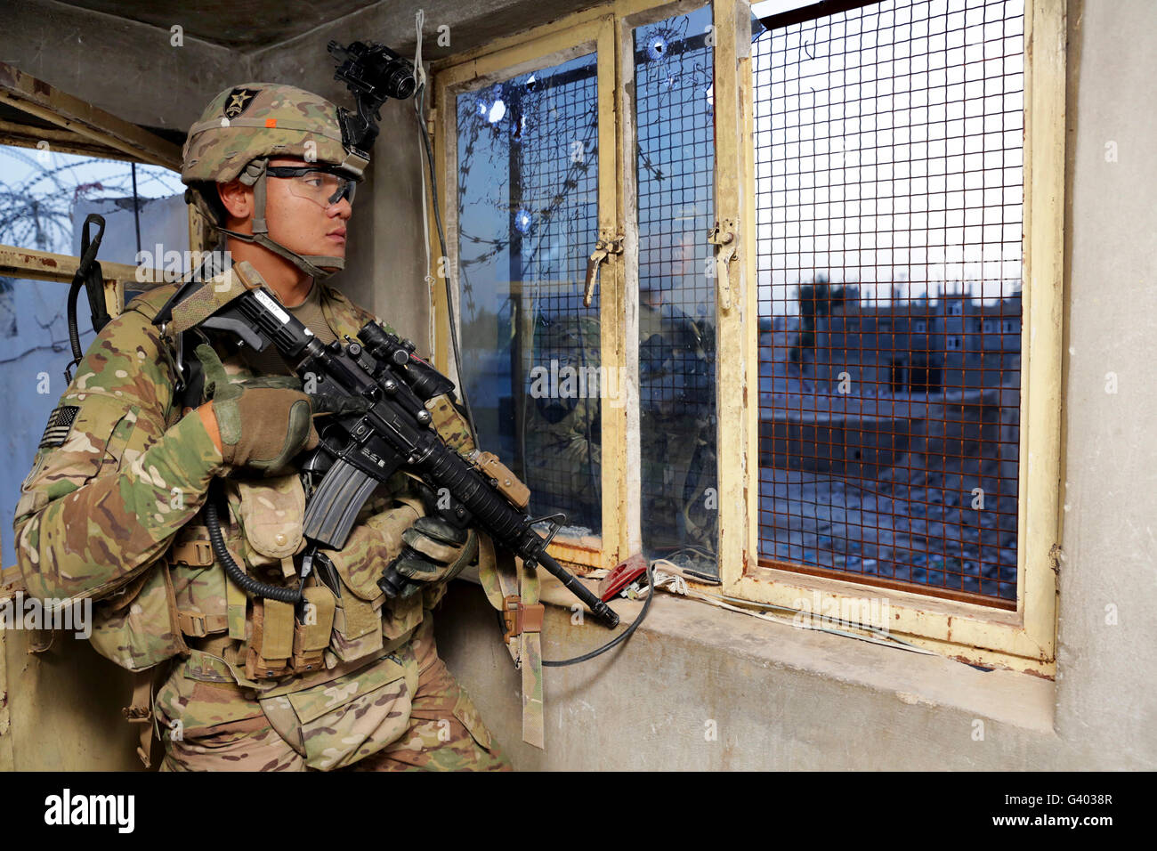 Especialista del Ejército de los Estados Unidos monitorea su entorno desde un puesto de guardia. Foto de stock