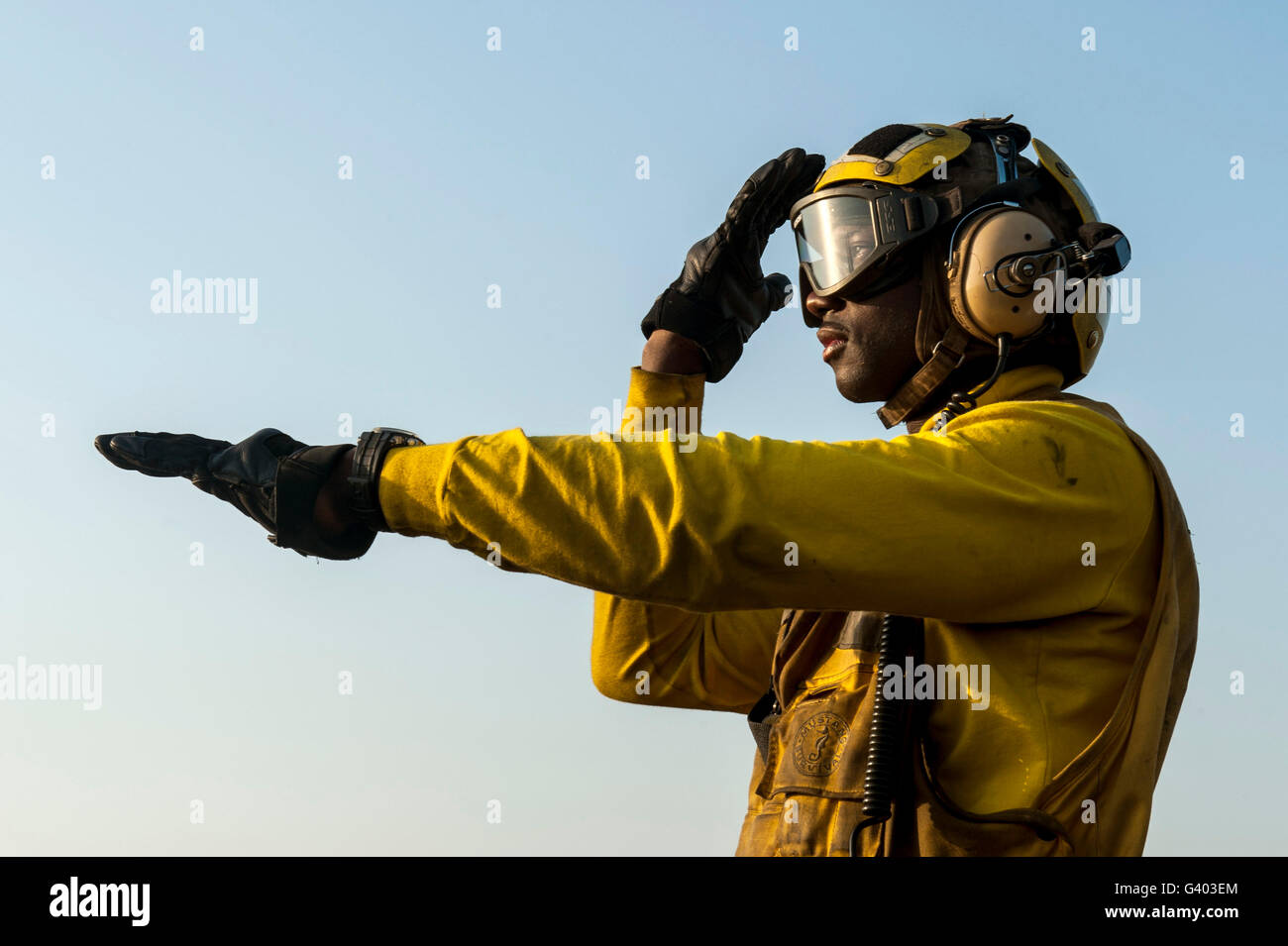 La aviación Boatswain's Mate dirige un helicóptero sobre la cubierta de vuelo. Foto de stock
