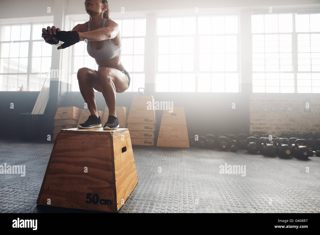 Foto de una mujer joven saltar en una caja como parte de la rutina de  ejercicios. Mujer Fitness haciendo crossfit box jump entrenar en el  gimnasio Fotografía de stock - Alamy