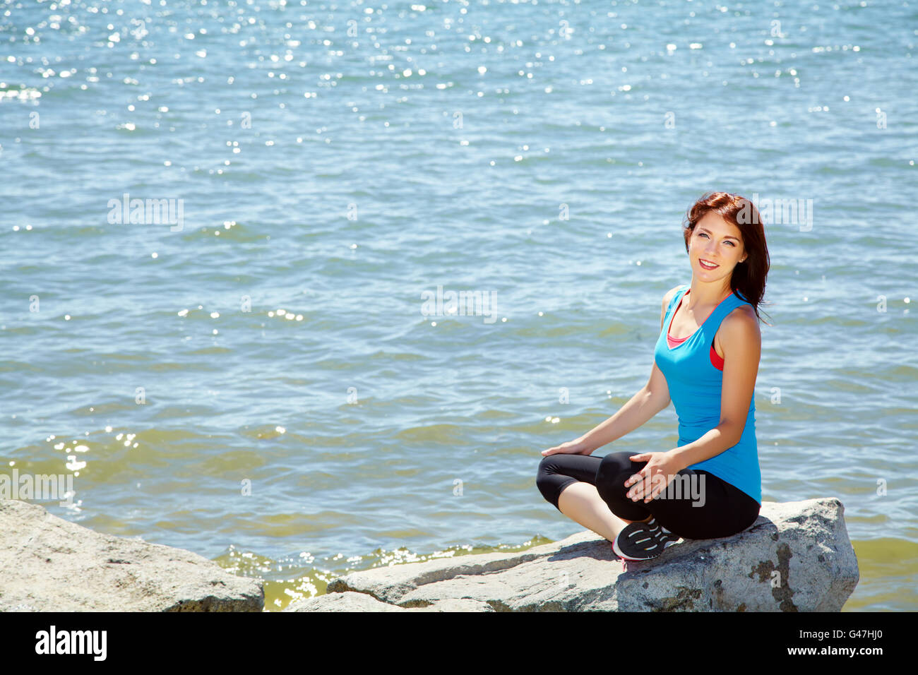 Mujer meditando en la orilla del mar Foto de stock