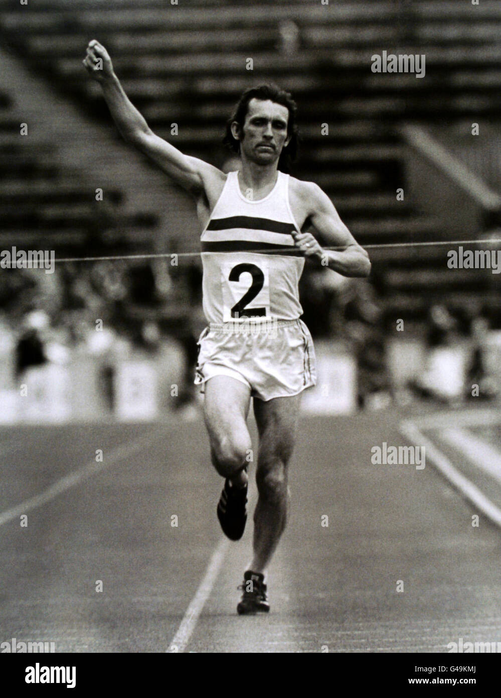 Tony Simmons, de Gran Bretaña, levanta el brazo para reconocer a la multitud como él gana los 10.000 metros Foto de stock