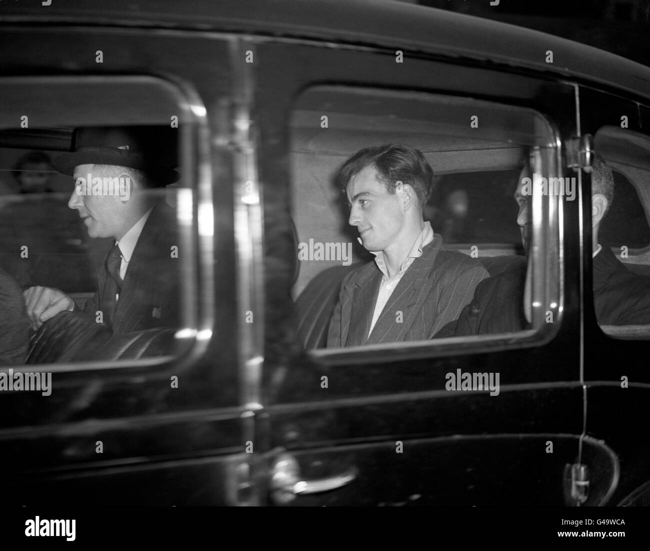 Charles Henry Jenkins fotografió en la parte trasera de un coche de la policía en su camino al Tribunal de Magistrados de Great Marlborough Street. Junto con los cómplices Christopher James Geraghty (no en la foto) y Terence Rolt (no en la foto), Charles Henry Jenkins fue acusado del asesinato del oficial de policía Alec de Antiquis, quien había abordado a los hombres tras una incursión en la joyería Jay&#8217;en Tottenham Street. El niño de 31yr años fue muerto a tiros en la calle Charlotte el 29 1947 de abril. Charles Henry Jenkins y Christopher James Geraghty fueron finalmente sentenciados a muerte después de un juicio en Old Bailey y ahorcados Foto de stock