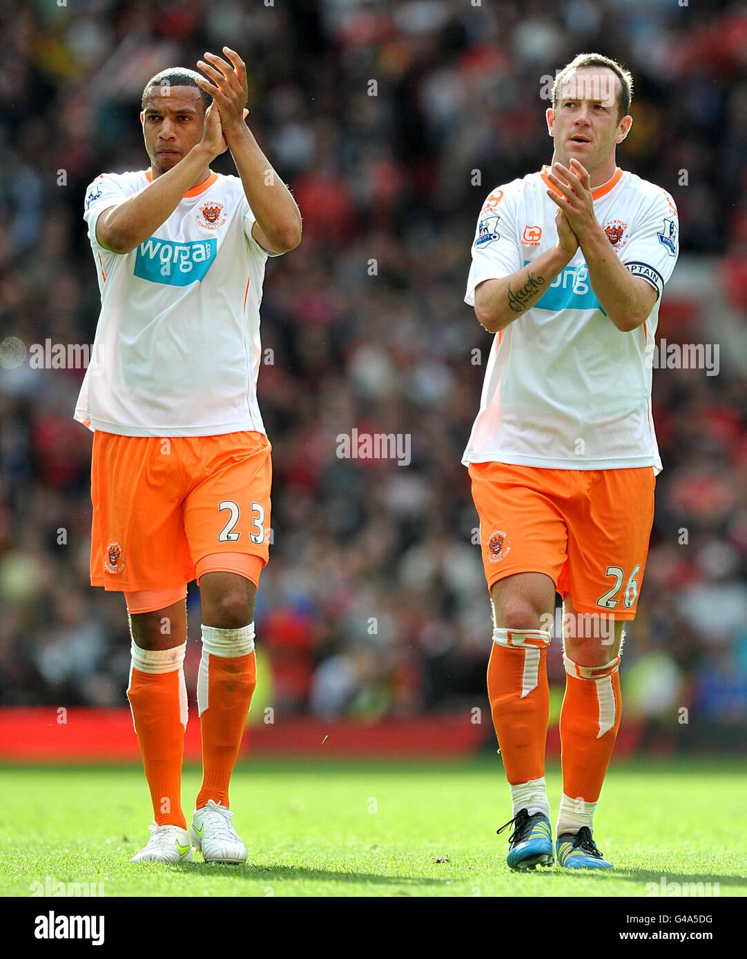 Matt Phillips (izquierda) y Charlie Adam (derecha) de Blackpool aplauden a sus fans después del silbato final. Foto de stock