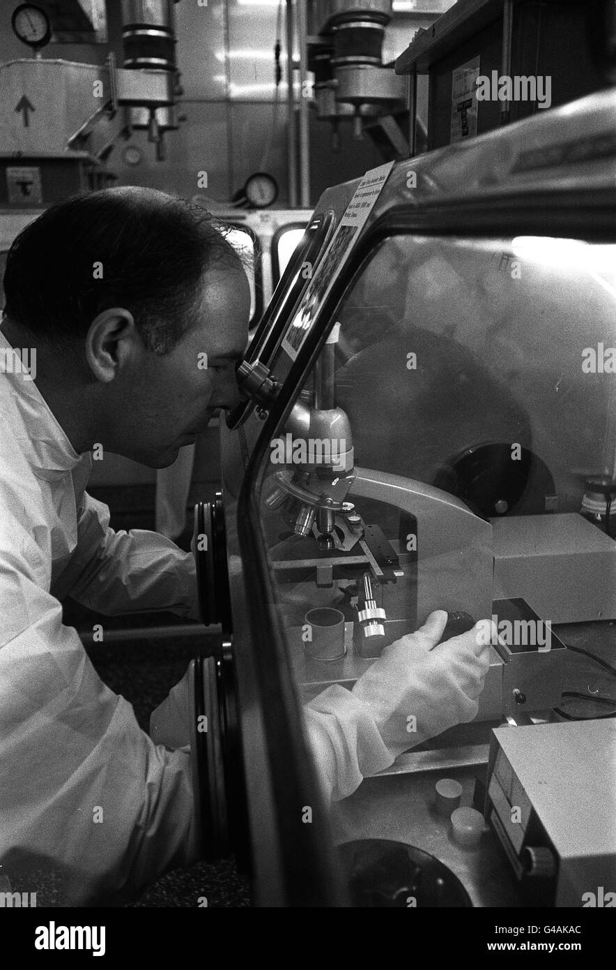PA News Foto 9/5/75 PORTON,WILTSHIRE UN LABORATORIO PARA EL ESTUDIO DE ENFERMEDADES INFECCIOSAS EN EL ESTABLECIMIENTO DE LA INVESTIGACIÓN microbiológica. Sr. DON conceder un alto funcionario científico es utilizando un microscopio dentro de uno de los armarios estancos al gas diseñado para dar absoluta de contención biológica. Foto de stock
