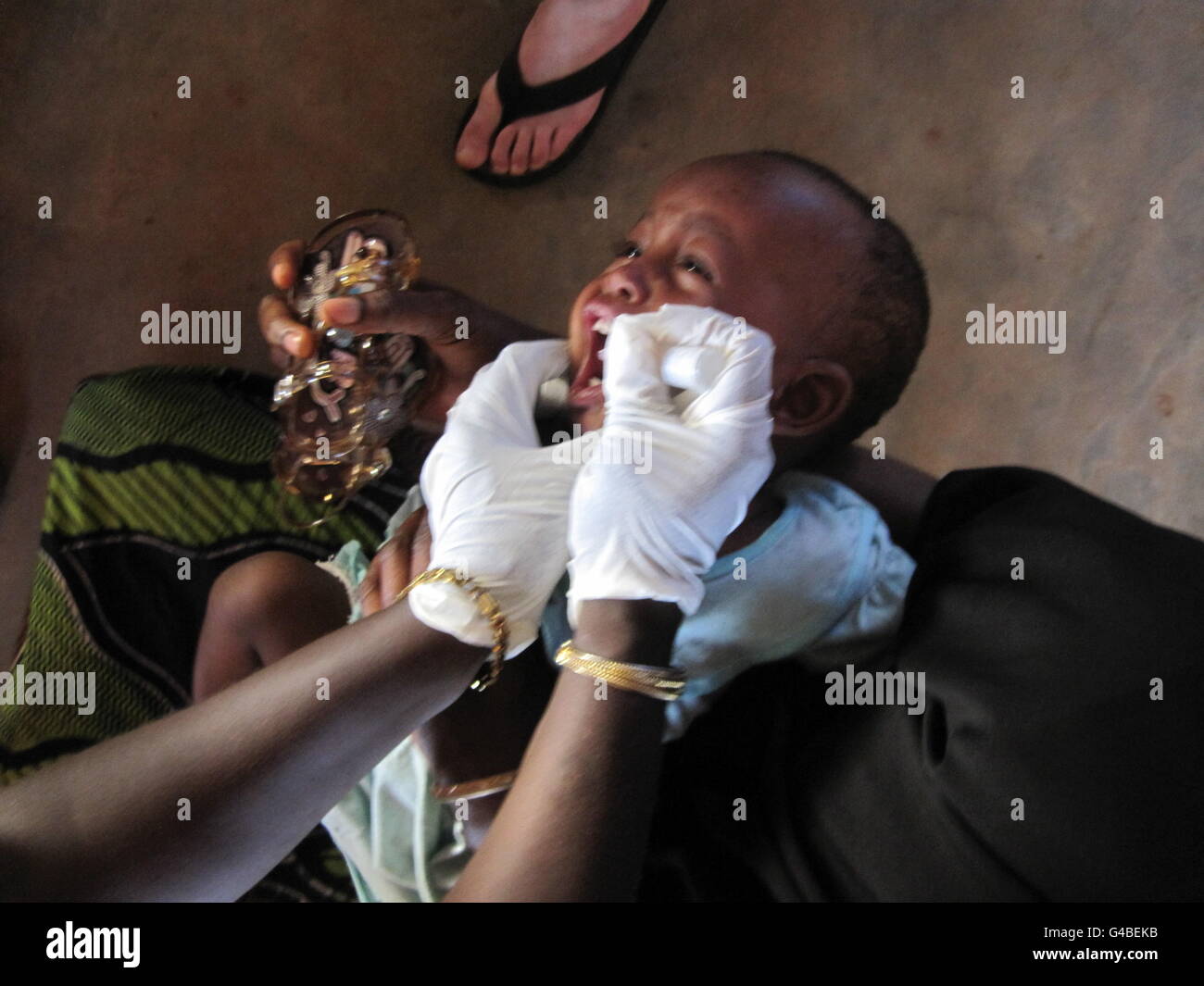 Una madre sin nombre tiene a su hijo, vacunado en la clínica de la estación de extensión de Sembehon cerca de Bo, en Sierra Leona. Foto de stock