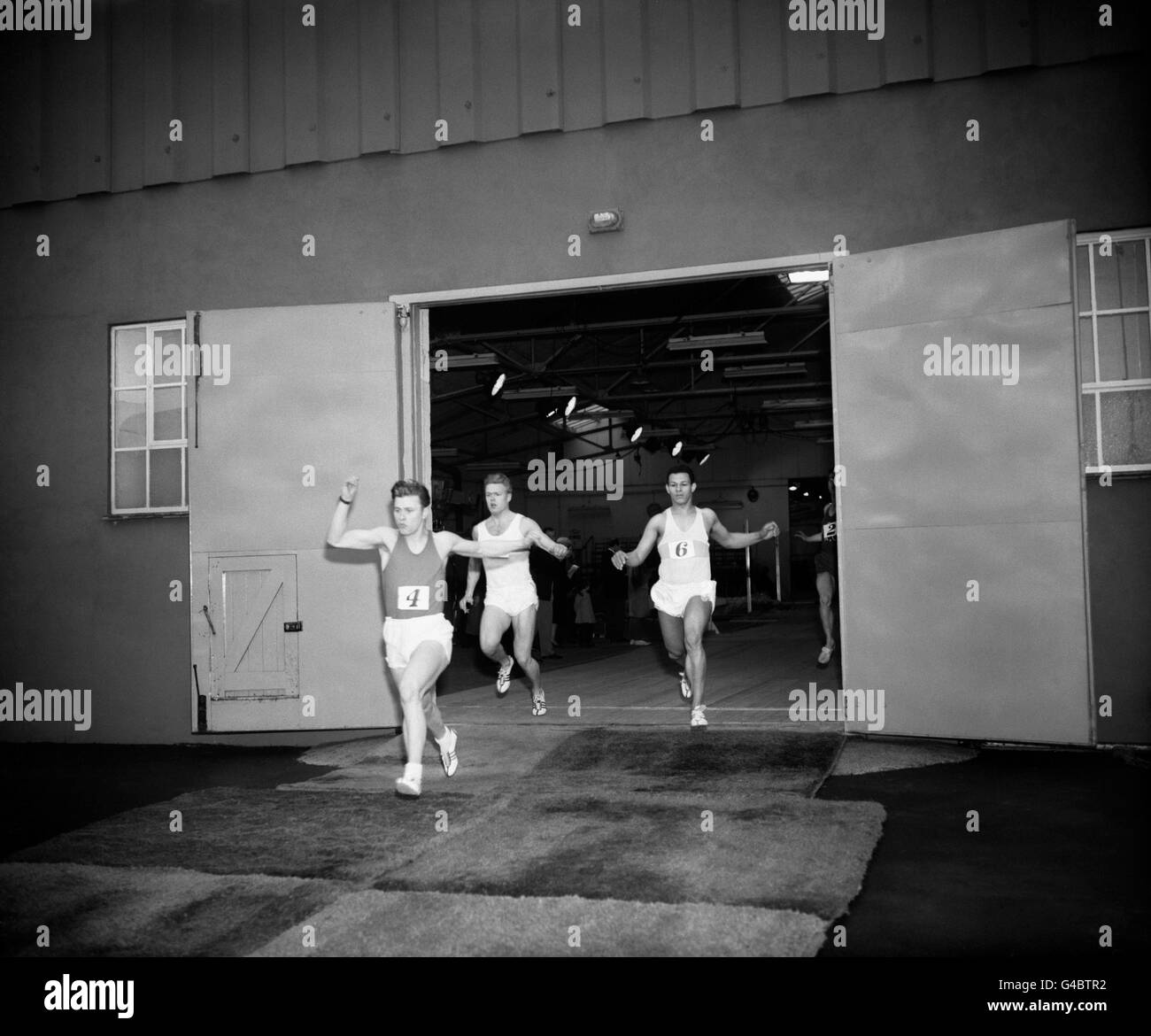 El final de la masculina 60 Yard Sprint, a través de la puerta del hangar, con el ganador J.E.P Morgan (4), P. Crosby (8), segundo y O.G Young (6), tercero. Foto de stock