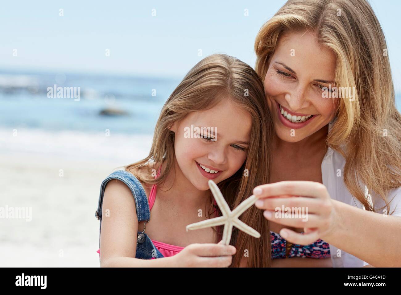 Modelo liberado. Hija de madre con la celebración de una estrella de mar. Foto de stock