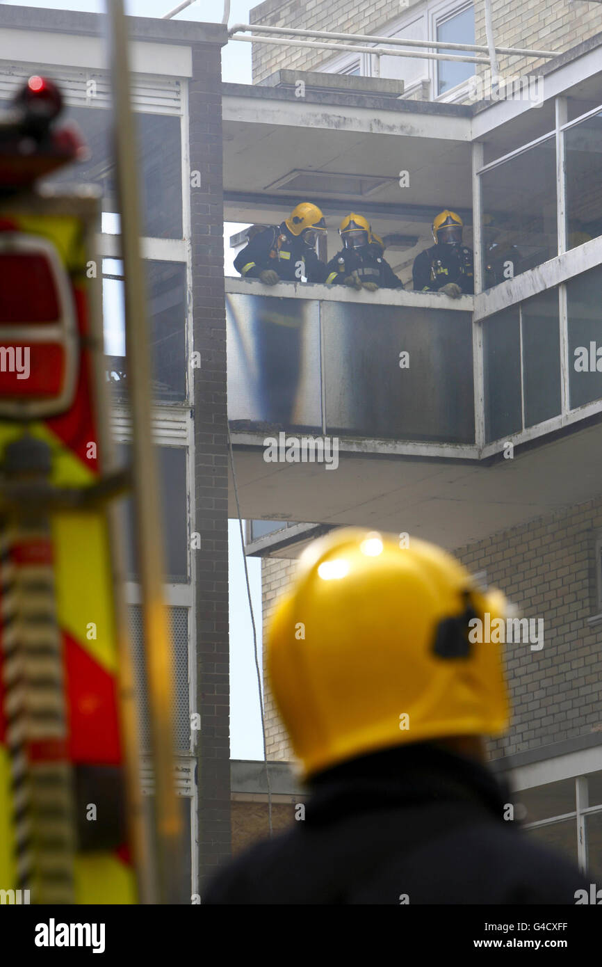 El personal de bomberos y rescate de Hampshire se prepara para entrar en un piso incendiado durante un ejercicio de 'fuego vivo' en Southampton. Foto de stock