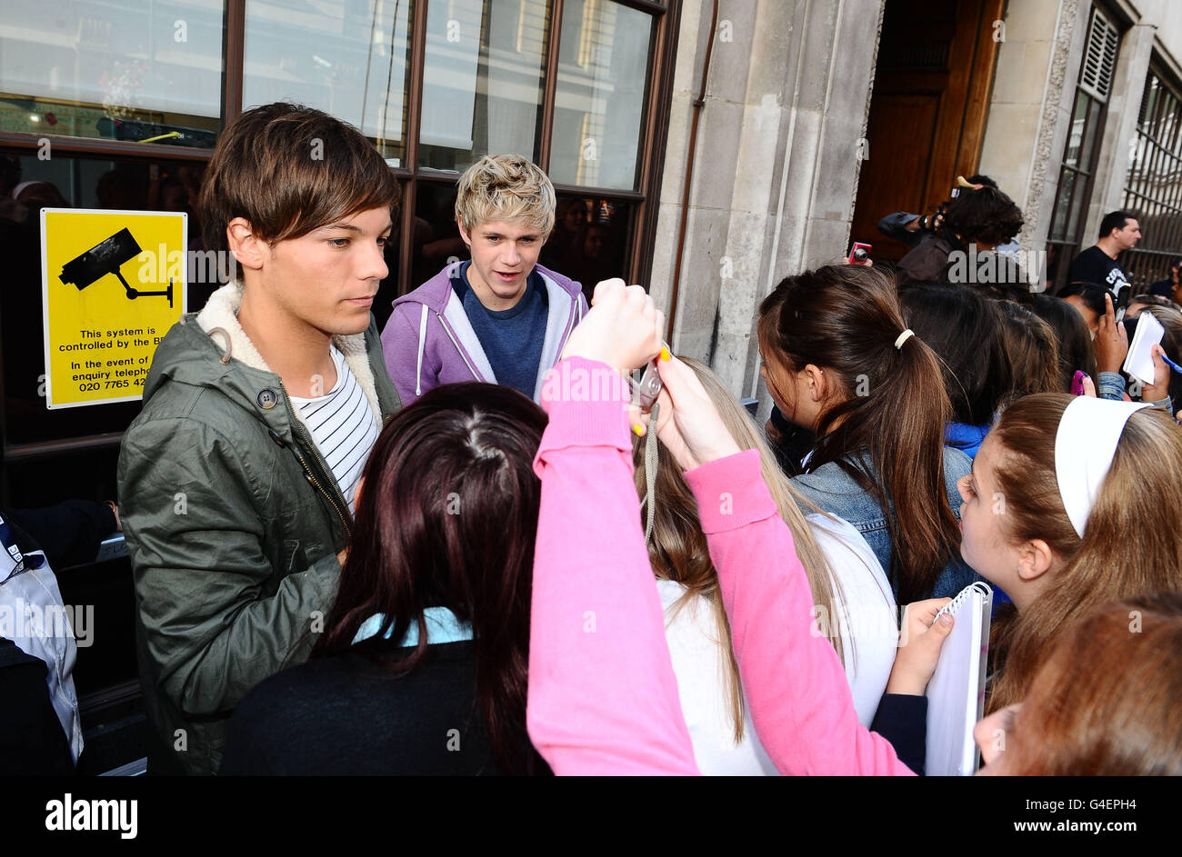 Louis Tomlinson (izquierda) y Niall Horan de One Direction se encuentran  con los fans fuera de Radio 1 en Londres Fotografía de stock - Alamy