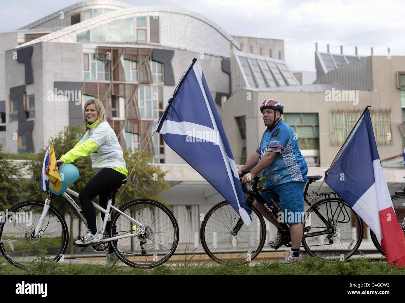 Natalie Hoy y Martin Burnett se unen a un grupo de ciclistas que parten de un viaje de recaudación de fondos a París cuando salen del parlamento escocés en Edimburgo. Foto de stock