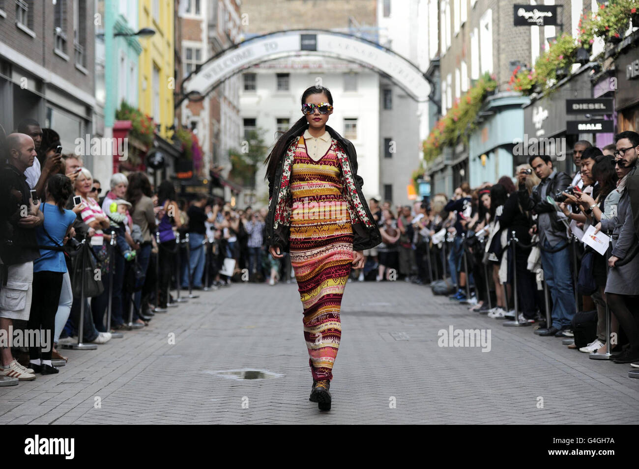 Un modelo lleva un vestido de London College of Fashion's College Shop en  Kingly Court y una chaqueta de Barbour Heritage durante la pasarela al aire  libre en el desfile de moda '
