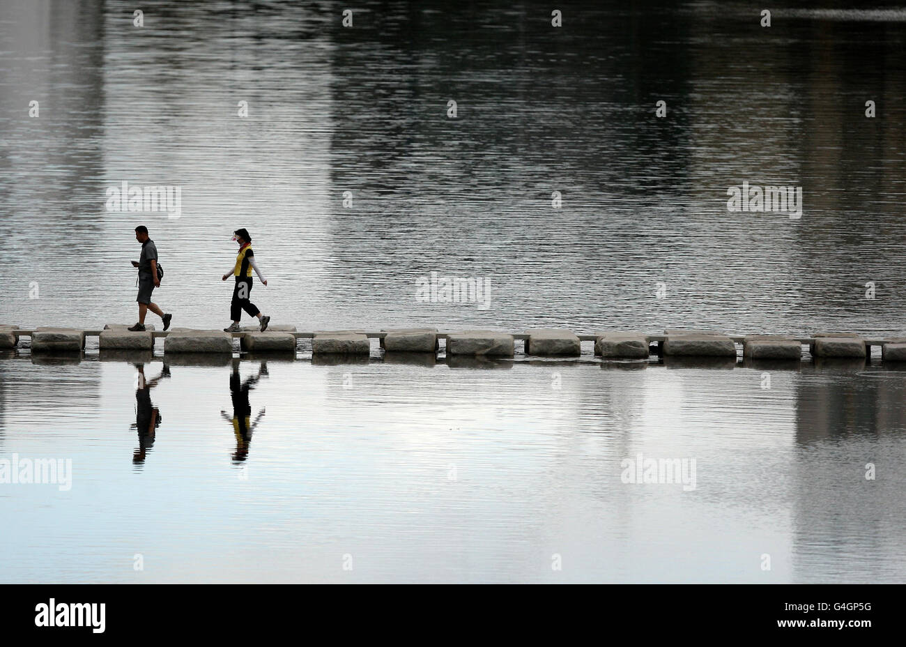 Los espectadores cruzan un río para ver la maratón masculina durante el noveno día del Campeonato Mundial de Atletismo de la IAAF en el Estadio Daegu en Daegu, Corea del Sur. Foto de stock