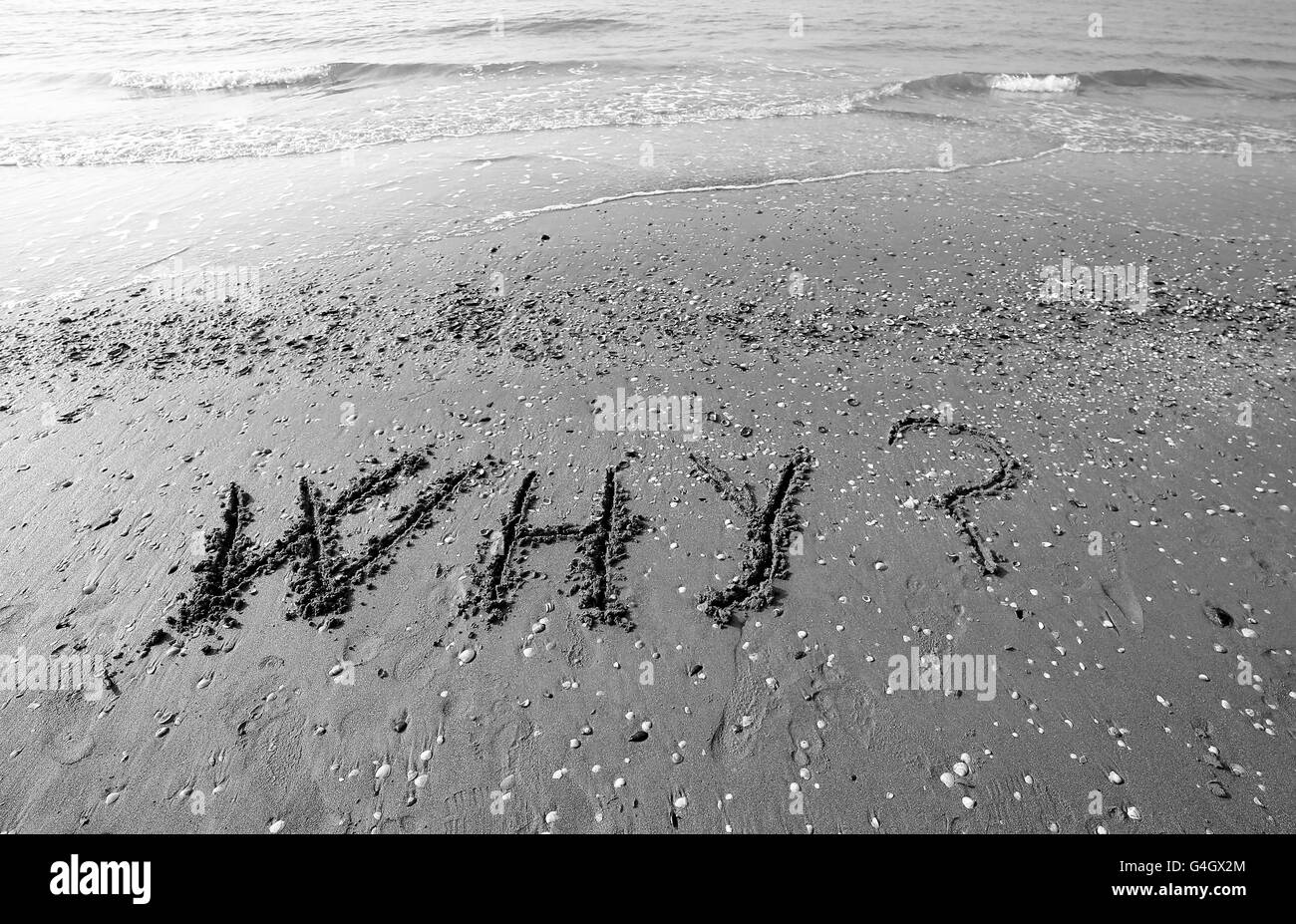 Gran lápida escrita sobre la arena del mar con las palabras porqué Foto de stock