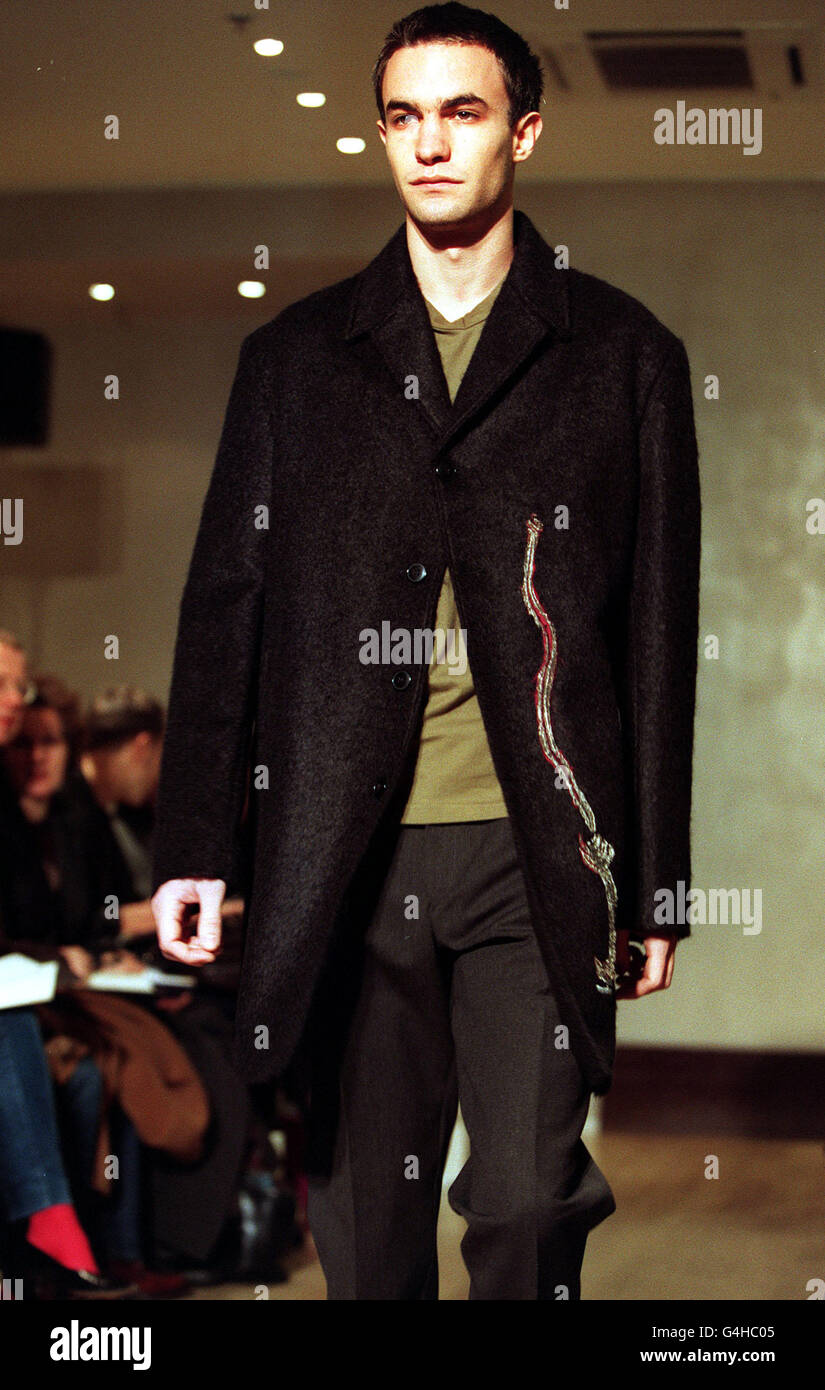 Un modelo presenta una chaqueta de carbón y pantalones grises diseñados por  John Rocha, durante la presentación de su colección durante la Semana de la  Moda de Londres para Hombres Fotografía de
