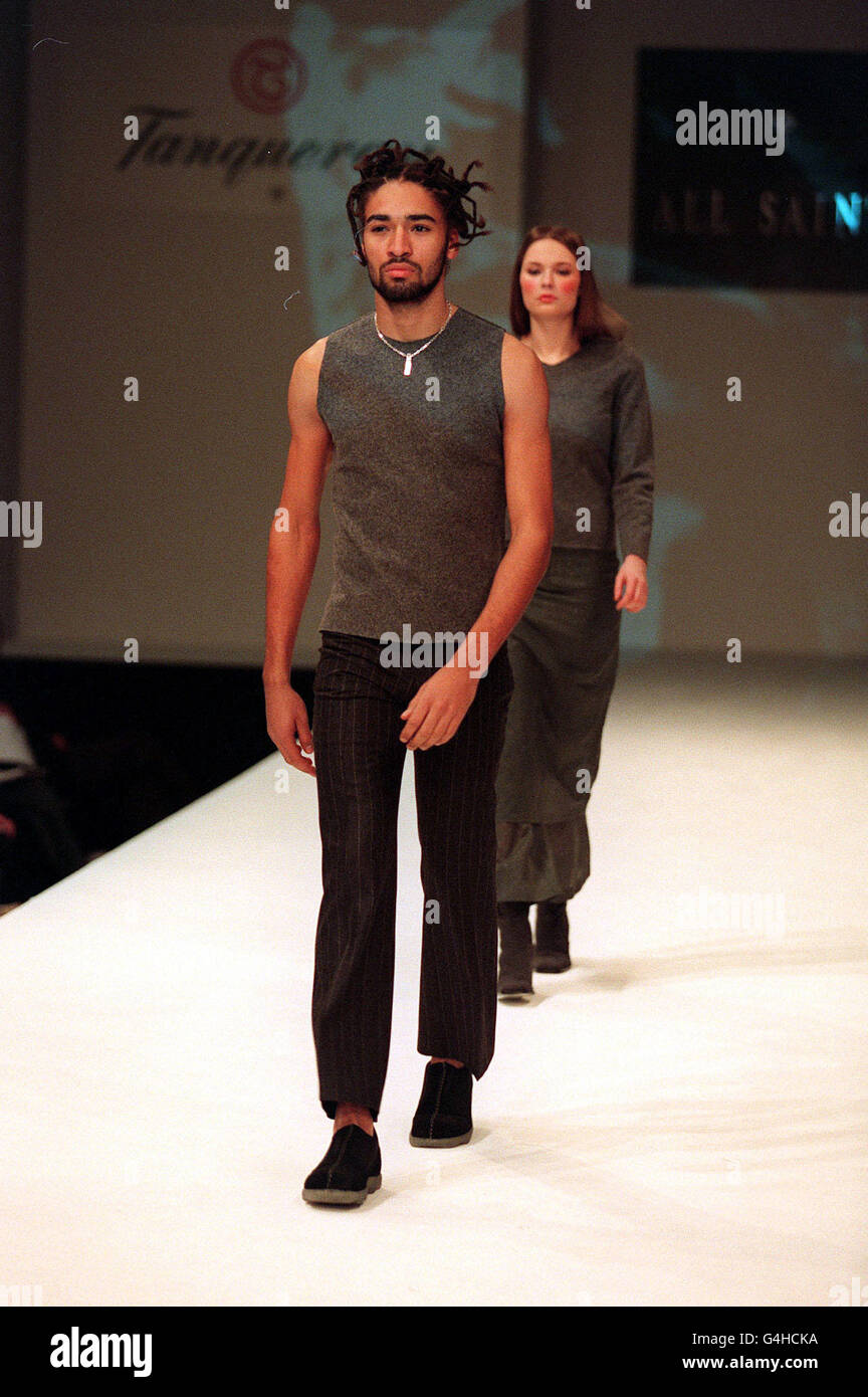 Un modelo lleva una camisa gris sin mangas y pantalones a rayas con  patillas diseñados por Elo, uno de los modelos masculinos más conocidos de  Gran Bretaña convertido en diseñador, el último