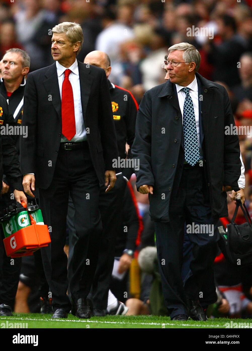 El gerente del Arsenal Arsene Wenger (izquierda) y el gerente del Manchester United Sir Alex Ferguson (derecha) caminan por la línea de contacto después del último silbato. Foto de stock