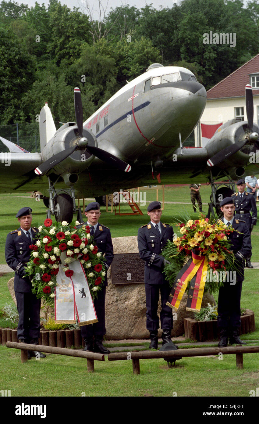 Aviadores de la 3ª División de la Luftwaffe Alemana, antes de colocar una corona en un monumento conmemorativo para conmemorar el 50 aniversario del aerodeslizador de Berlín, en un complejo del Ejército Británico en el distrito de Spandau de Berlín. Detrás hay un Douglas C-47 Skytrain o 'akota', de la Royal Canadian Air Force, que participó en el épico aerodeslizador. Foto de stock