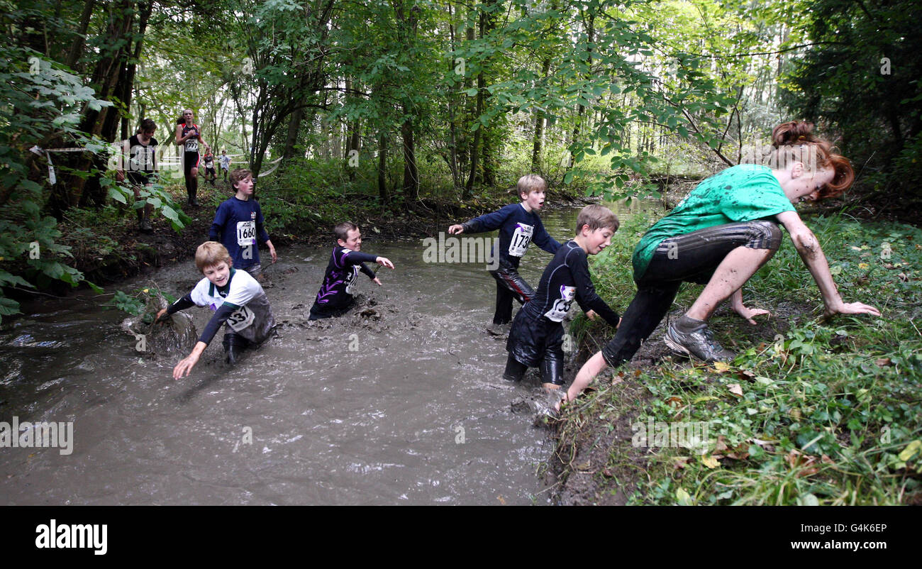 Los competidores luchan por el barro en el curso de 7 millas a través de los terrenos de Eastnor Estate en Herefordshire durante la aventura de Mud Runner. Foto de stock
