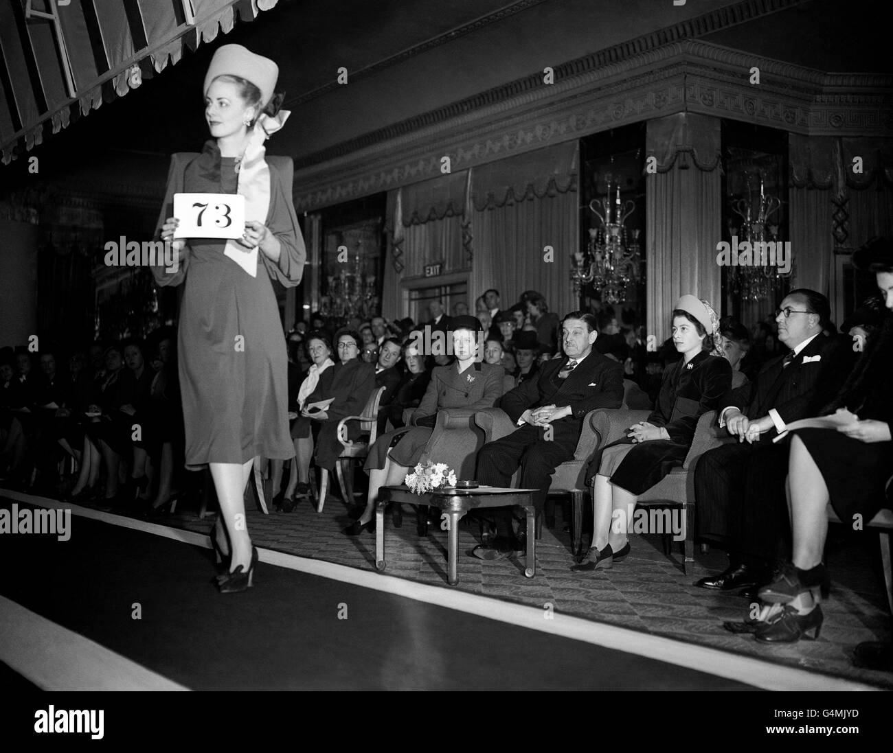 La princesa Elizabeth, sentada en segundo lugar de la derecha, mirando el desfile de modelos, organizado por los diseñadores de Millinery asociados de Londres en el Hotel Dorchester. Foto de stock