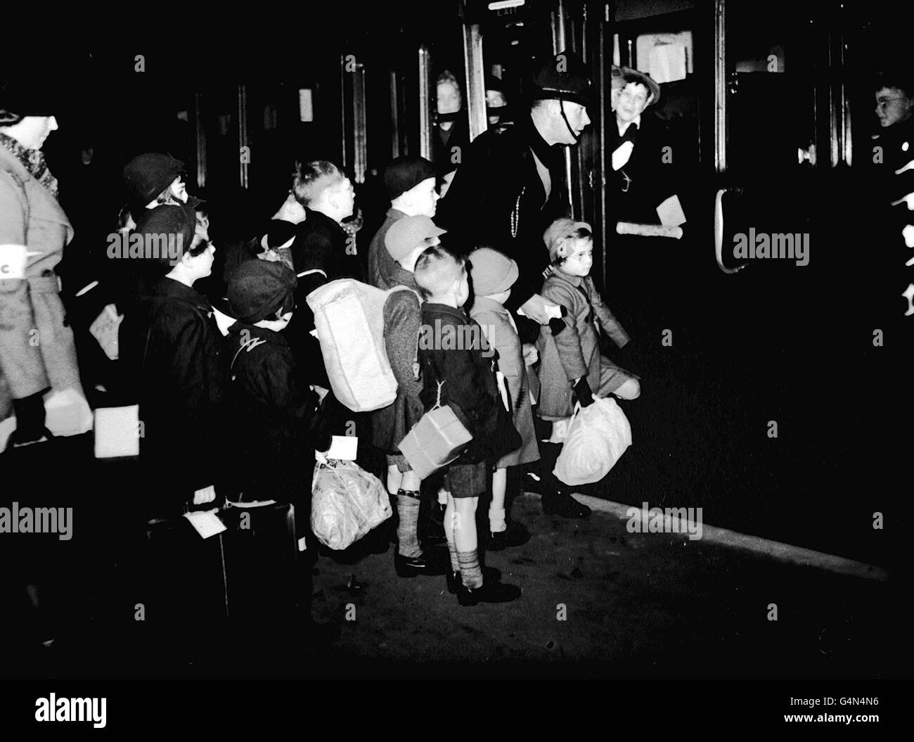 Los evacuados salen de una estación de Londres hacia el País Occidental al comienzo de la Segunda Guerra Mundial. Los niños llevan sus máscaras de gas en cajas de cartón atadas con cuerdas. Septiembre 1939. Foto de la colección de la Segunda Guerra Mundial de PA. Foto de stock
