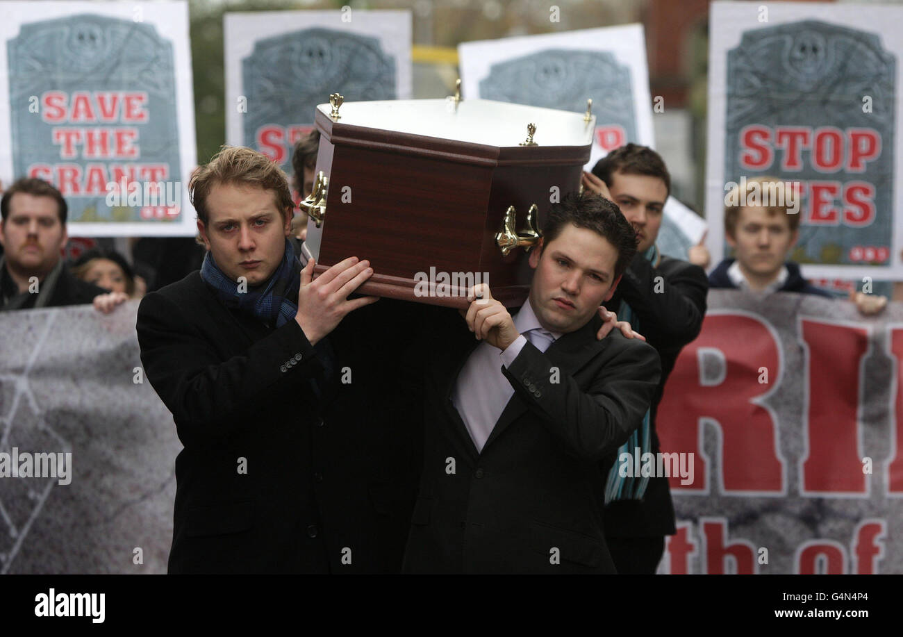 Colm Murphy y Gary Redmond, miembros de la Unión de Estudiantes en Irlanda (USI) llevan un ataúd a las puertas de Leinster House en Dublín mientras los estudiantes hoy lloraban el 'estado de la educación' con un cortejo funerario a través de Dublín. Foto de stock