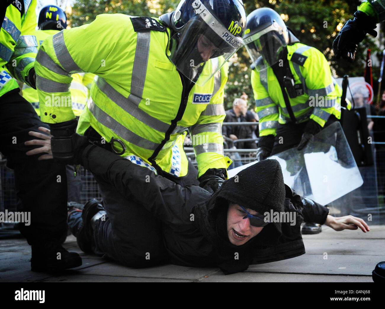 Un estudiante de demostración es detenido cerca de la Bolsa de valores en Londres, durante la última marcha de las tasas de estudiante. Foto de stock