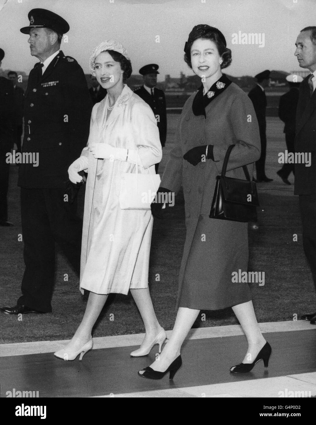 La Reina Elizabeth II y la Princesa Margaret caminan desde el avión BOAC que llevó a la Princesa Margaret al aeropuerto de Heathrow desde su gira por el Caribe. Foto de stock