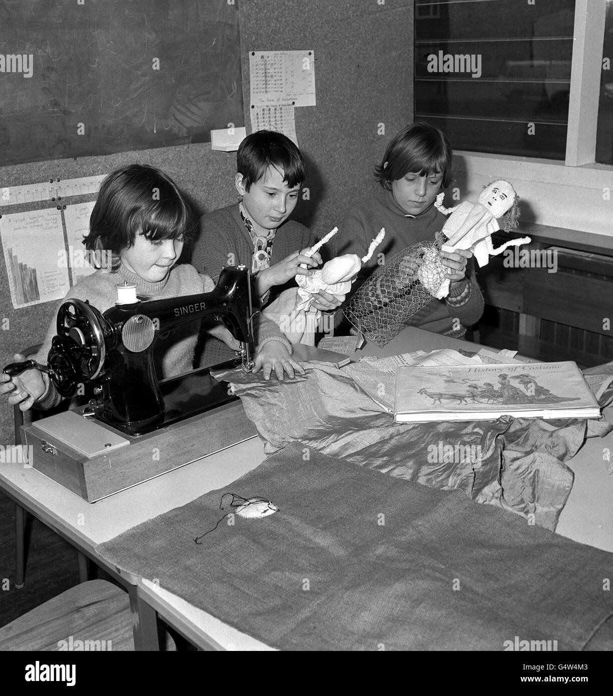 Foto PA 22/2/68 Tres niños escolares que trabajan alrededor de la máquina de coser en la Escuela Vittoria en Islington, Londres Foto de stock