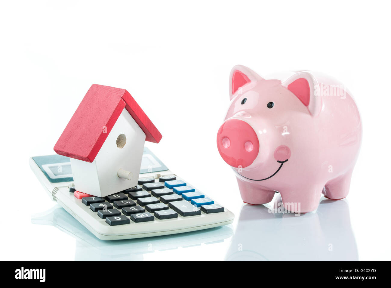 Ahorrando para comprar una casa, hucha, house y una calculadora. Foto de stock