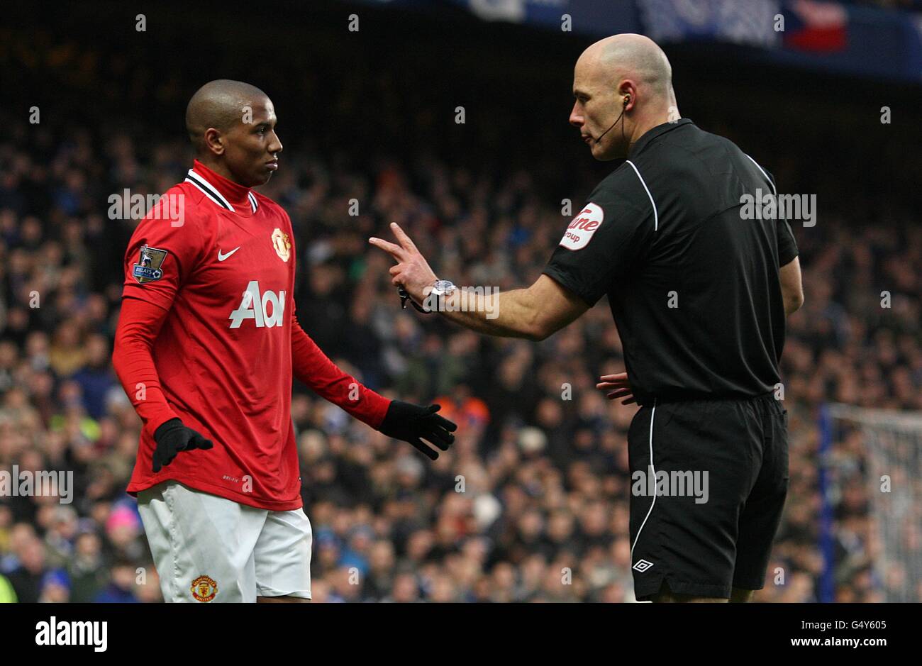 El árbitro Howard Webb premia a Ashley Young de Manchester United (izquierda) después Una falta en el Chelsea Branislav Ivanovic Foto de stock