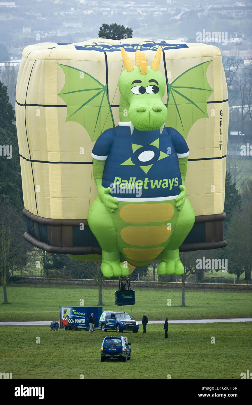 Los equipos de vuelo inflan el globo aerostático Palletways Dragon en Ashton Court, Bristol, para marcar el inicio del club International Bristol Balloon Fiesta 100. Foto de stock