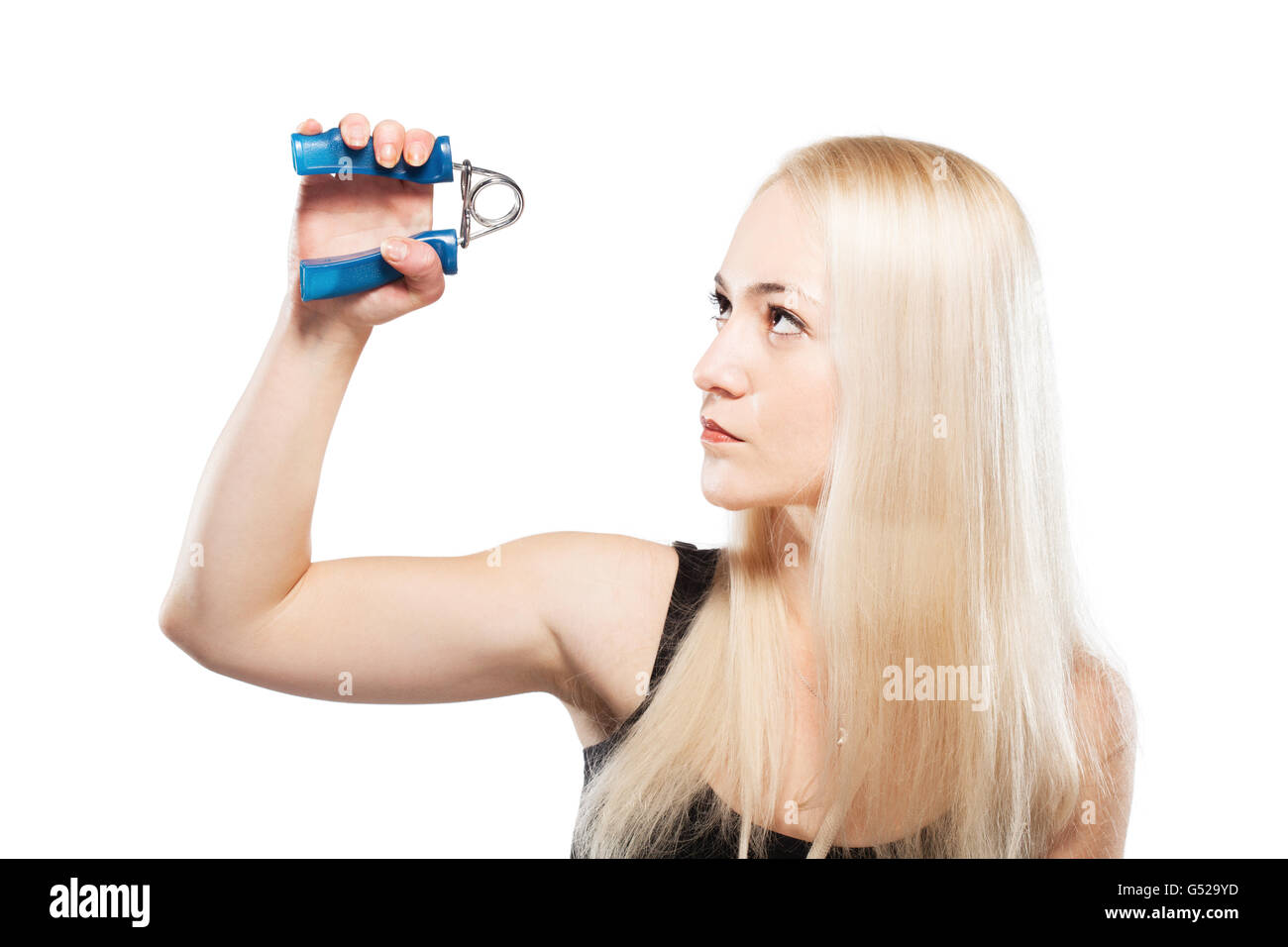 Fitness chica rubia ejerce su brazo con una herramienta de agarre por resorte Foto de stock