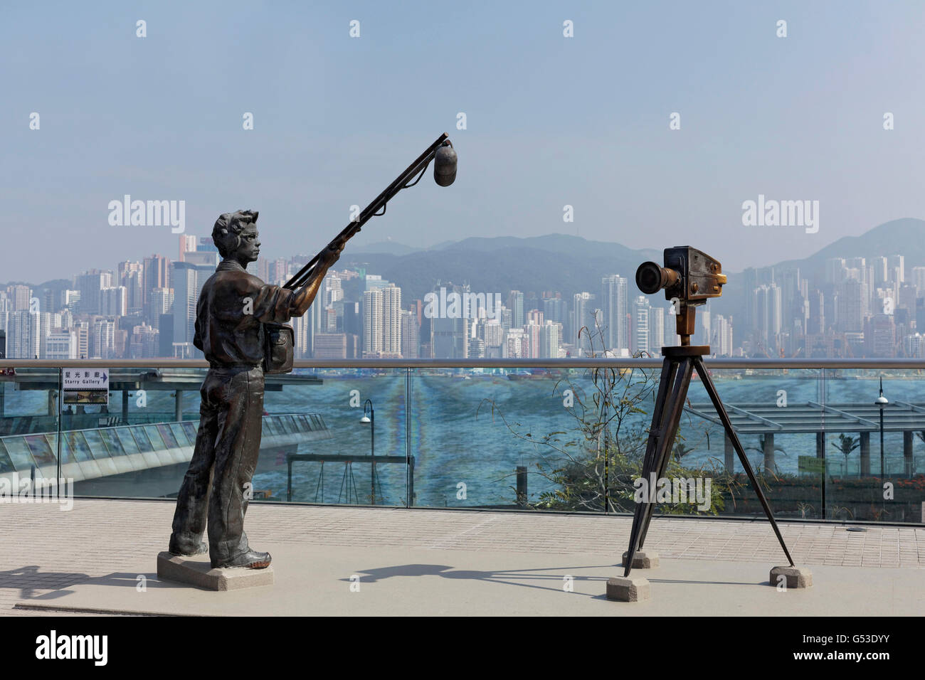 Asistente de sonido y cámara de cine, esculturas de bronce, la Avenida de las estrellas con vistas de la isla de Hong Kong, Tsim Sha Tsui, Kowloon Foto de stock