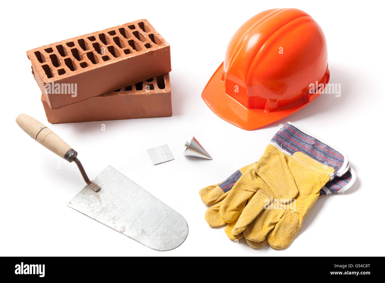 Varios accesorios de construcción llana, ladrillos, caen en picado, casco y guantes aislados sobre fondo blanco. Foto de stock