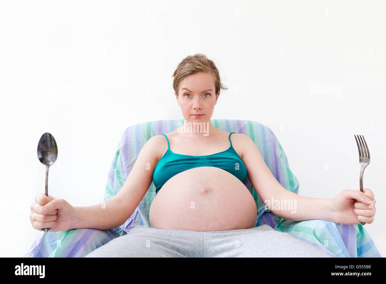 Insatisfecho, hambrientas mujer embarazada esperando la cena Foto de stock