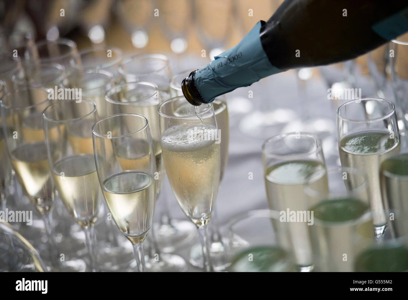 Champaña servido en copas de una botella durante una recepción con champán. Foto de stock