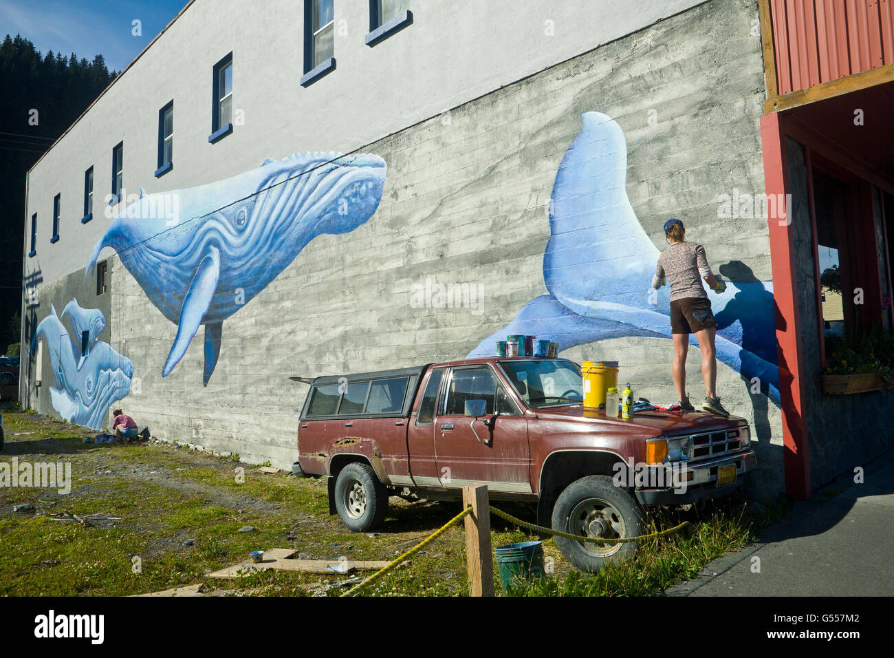 Artista Justine Pechuzal su pintura mural 'Sea-ward Bound" que representan las ballenas jorobadas (Megaptera novaeangliae), Seward, Alaska Foto de stock