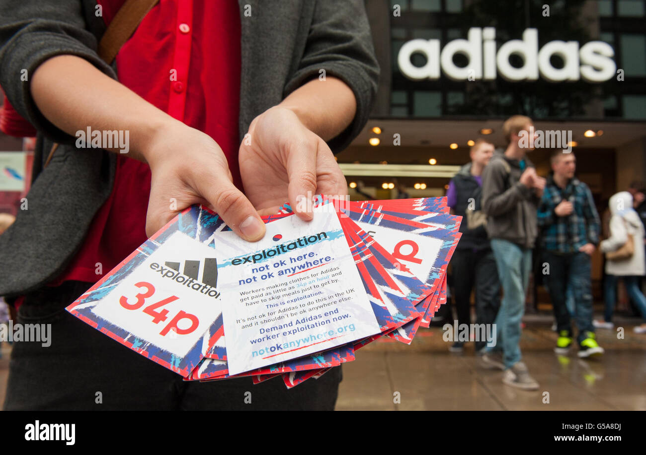 Un miembro del grupo de campaña Guerra contra la Deseo tiene etiquetas de precios falsas para ropa Adidas fuera de la Adidas en Oxford Street, en el centro Londres, parte